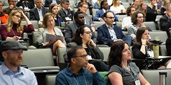 conference attendees seated in lecture hall during presentation