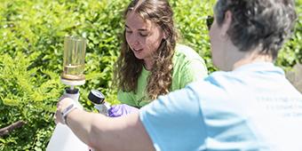 undergrad chemistry student takes water samples from Monongahela River